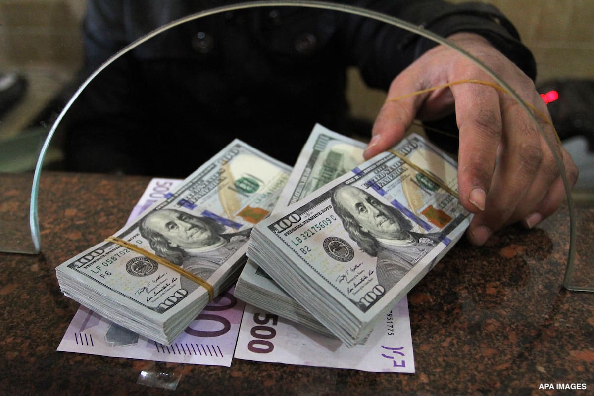 A Palestinian money changer counts money at an currency exchange office