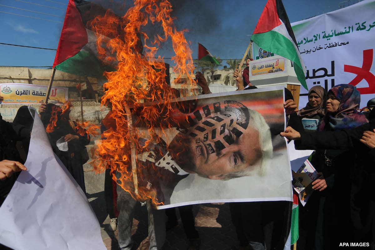 Palestinian protesters burn posters depicting the faces of US President Donald Trump and Israeli Prime Minister Benjamin Netantyahu during a protest against US President Donald Trump's Century Deal "expected peace plan"