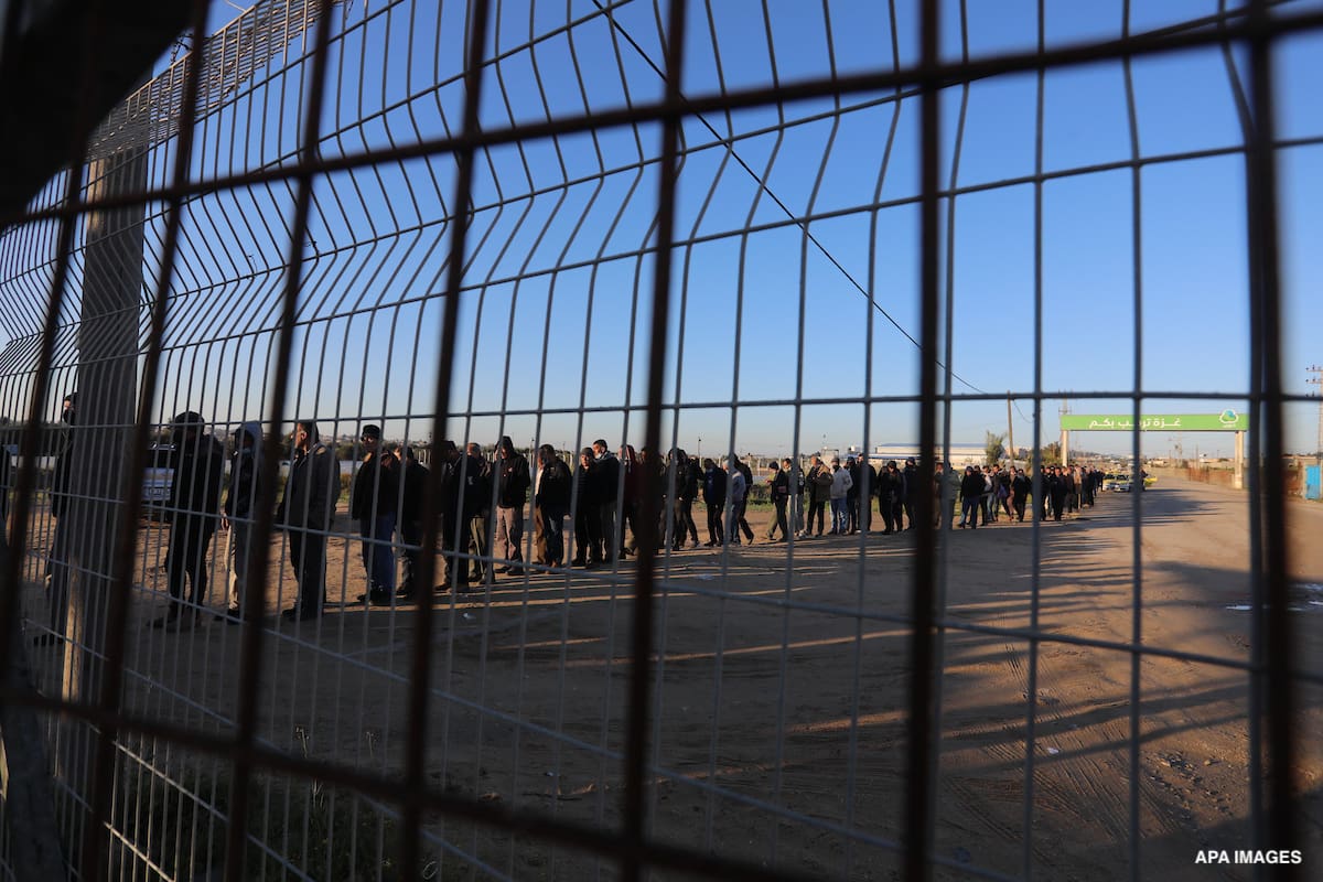 Palestinian workers wait at the Erez crossing as they prepare to leave Beit Hanun