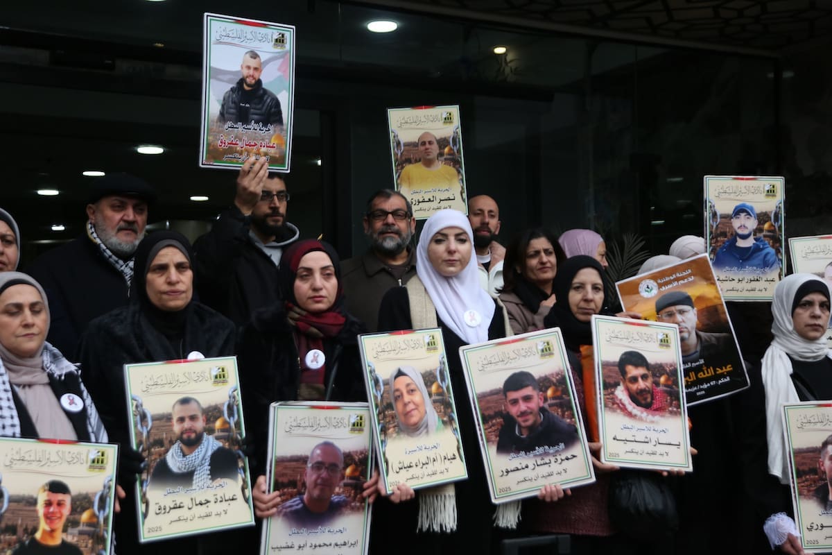 Families of Palestinian prisoners hold photos of their sons detained in Israeli prisons during a solidarity march